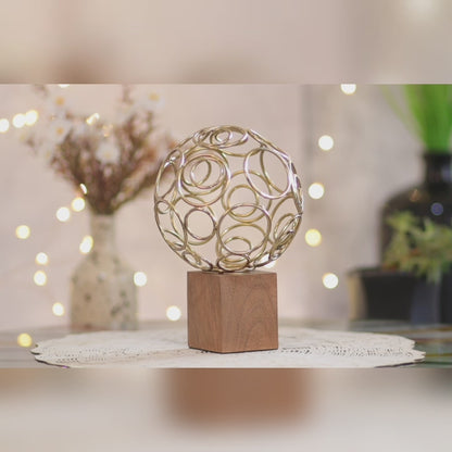 Kezevel Steel Ring Ball Showpiece - Handcrafted Golden Ring Ball Table Accent on Wooden Base, Metal Showpiece for Home Decor, Size 14.61X14.61X21.59CM